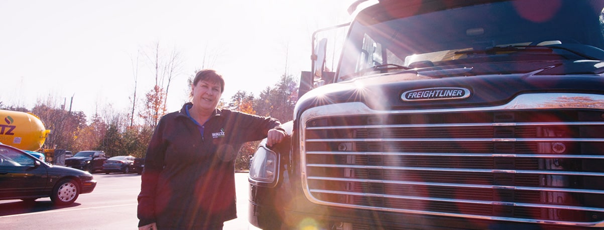 sue waltz standing next to truck